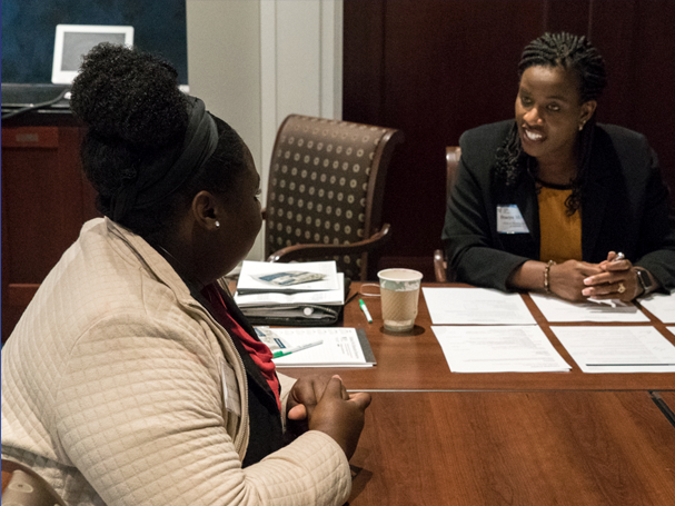 an Atlanta Fed employee talking with another person at a desk