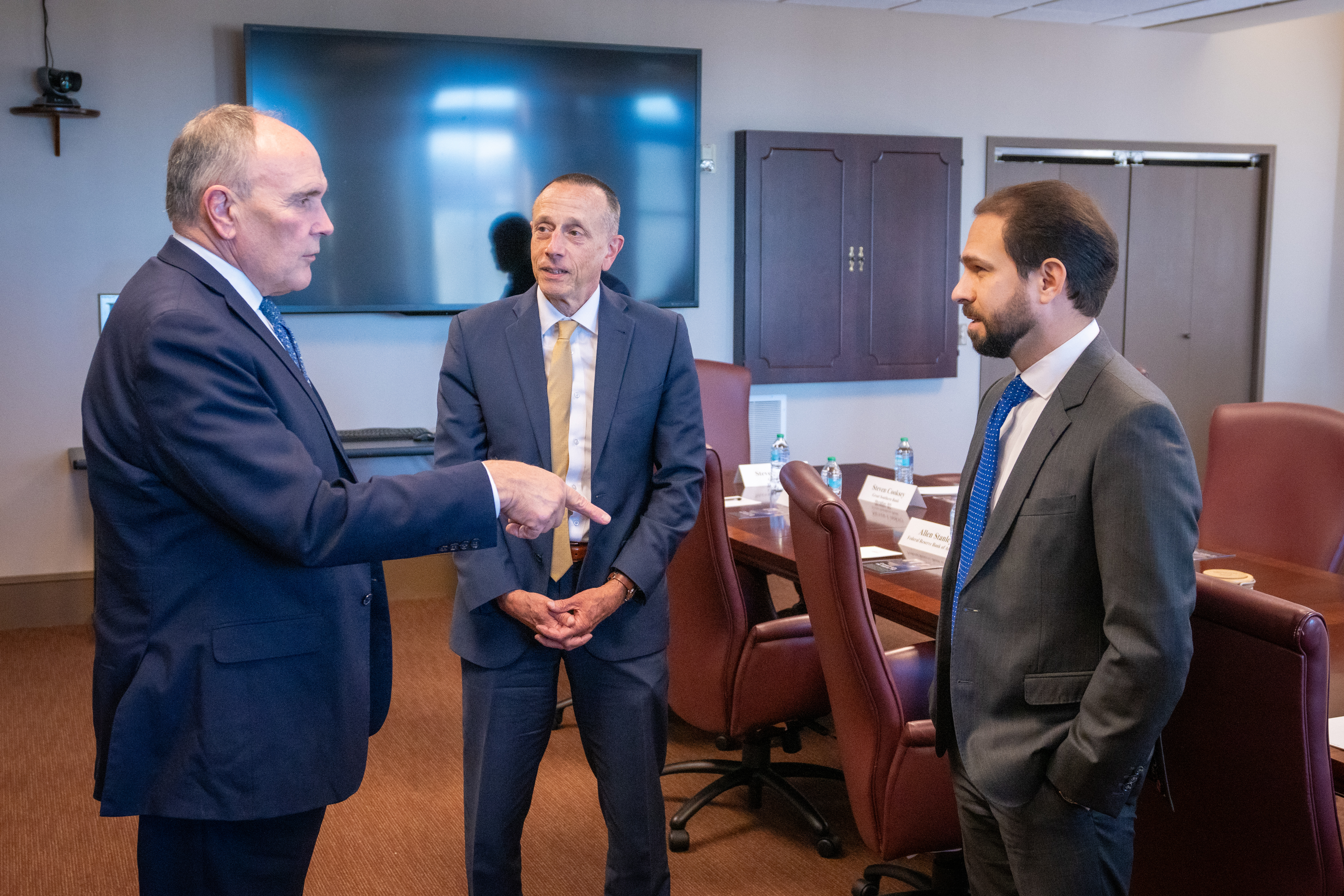 head of community and regional supervision, allen stanley (center), flanked by two bankers, duane dewey and casey hill