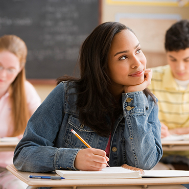 a young female smiling in thought in class