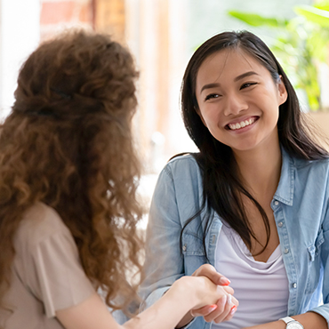 one female smiling facing another female