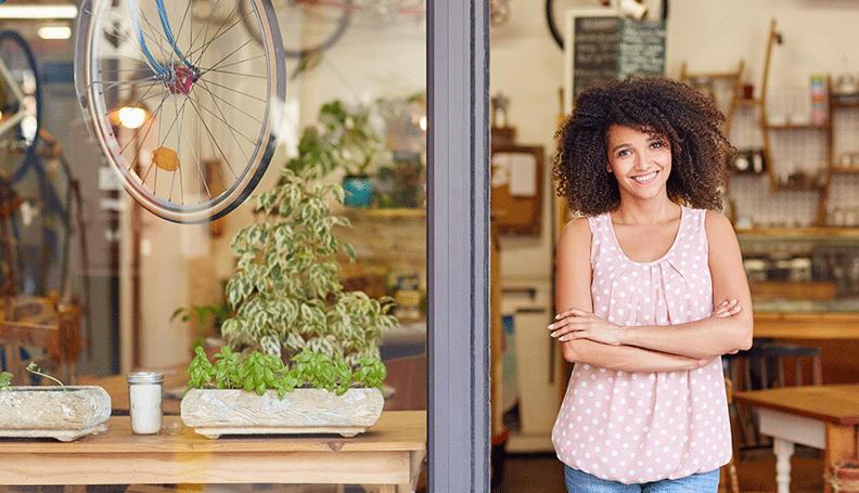 a woman in the foreground standing at the threshold of a cycling shop