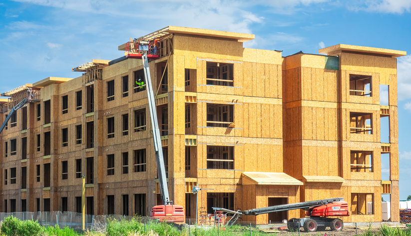Long shot of apartment complexs' wooden frame being built from scratch