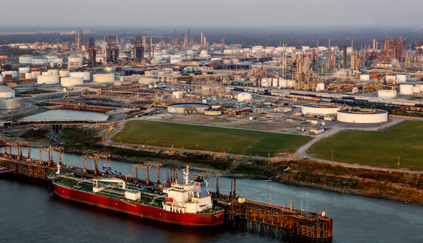 aerial photograph of an oil refinery complex in New Orleans, Louisiana with a ship docked just offshore