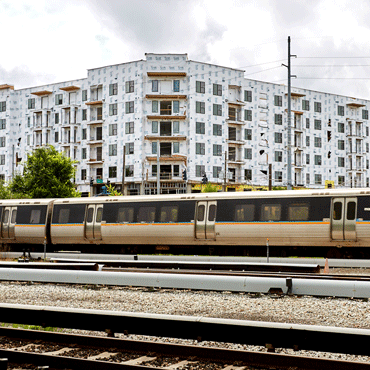 photograph of a MARTA train passing in front of a new housing development under construction