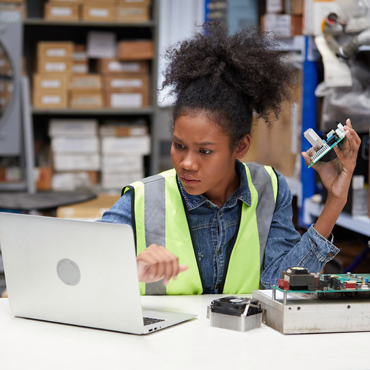 young woman looking at computer holding parts