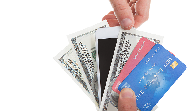 hands holding money, credit cards, and iphone