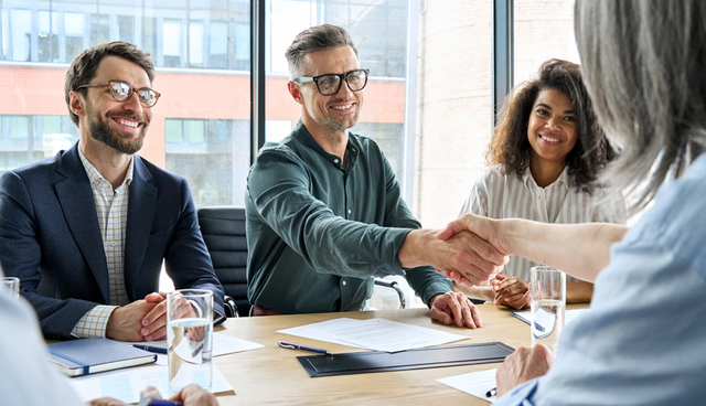 people meeting with one man shaking the hand of another