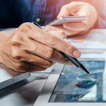 closeup of businessmen using phone and tablet on a desk