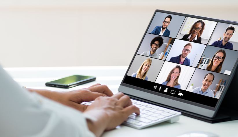 hands typing on keyboard with team on tablet video call