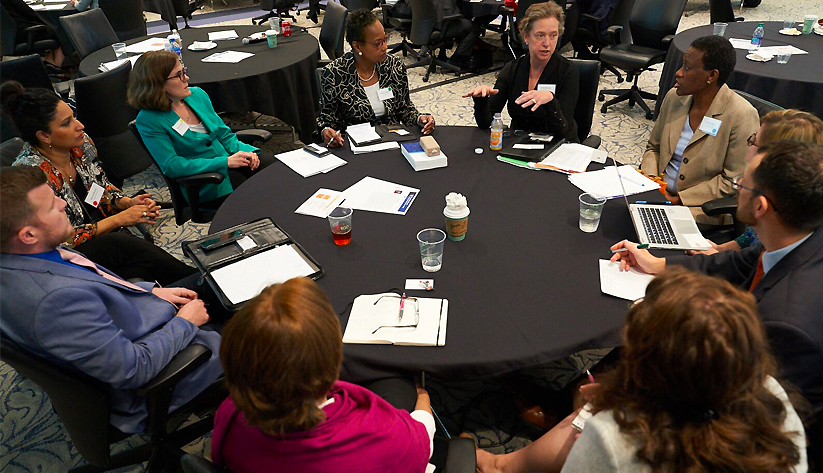 Photo of people sitting around a table in discussion