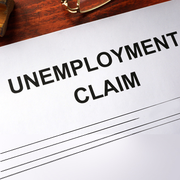 photo illustration of a paper titled Unemployment Claim laying on a desk