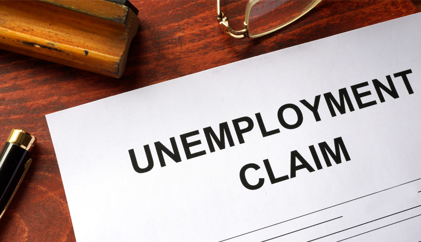 photo illustration of a paper titled Unemployment Claim laying on a desk