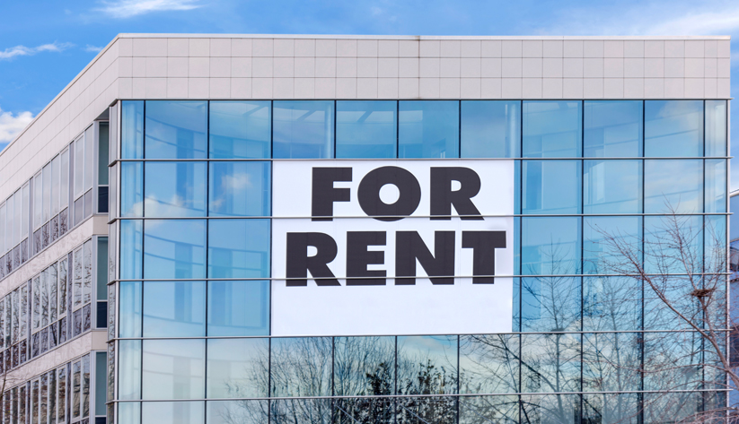 large "for rent" sign on glass building