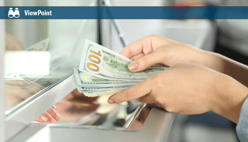 Hands holding several hundred dollar bills at a bank teller window