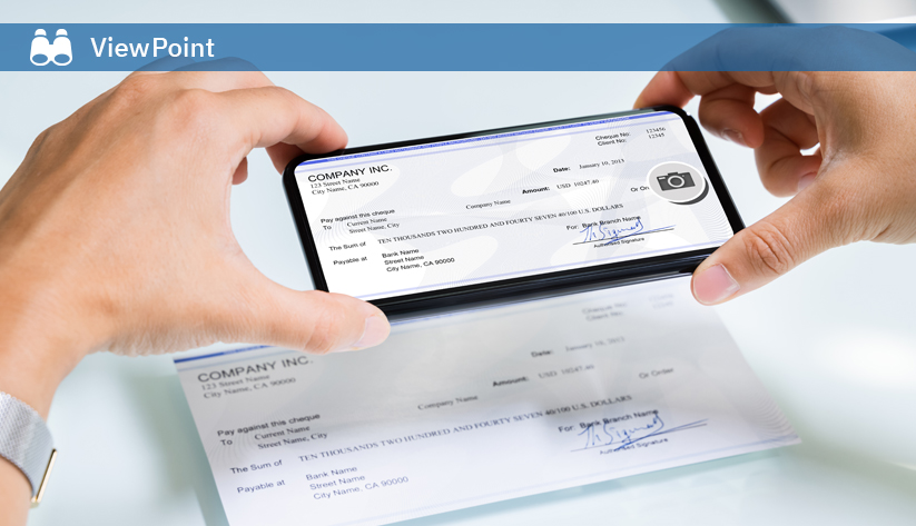 Hands holding smartphone photographing a business check
