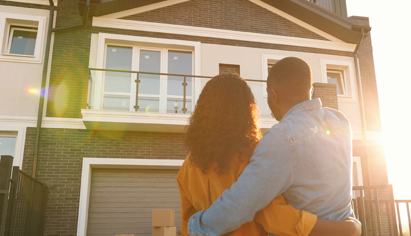 Couple standing in front of new house