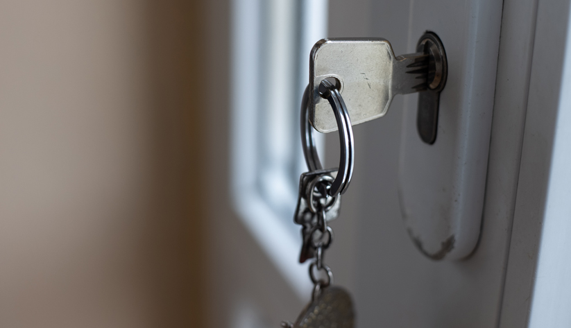 key inserted into keyhole of house frontdoor