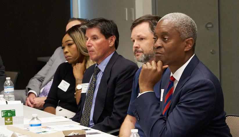 Raphael Bostic sitting with other people at table