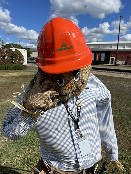 Person wearing hard hat and scare crow mask