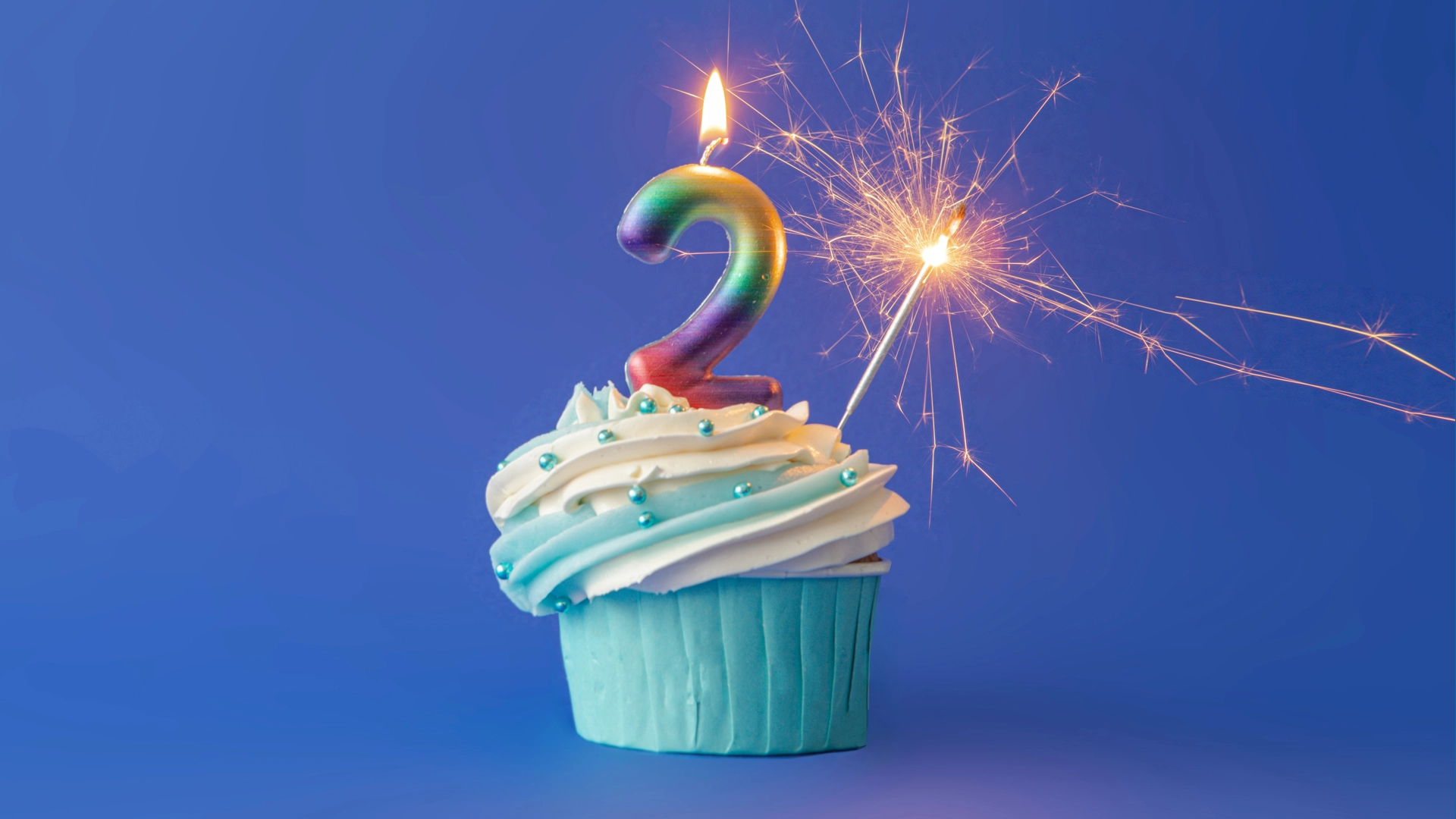 Cupcake with a number two candle and a sparkler, depicting the numeral 2, which is the Fed's target annual inflation rate