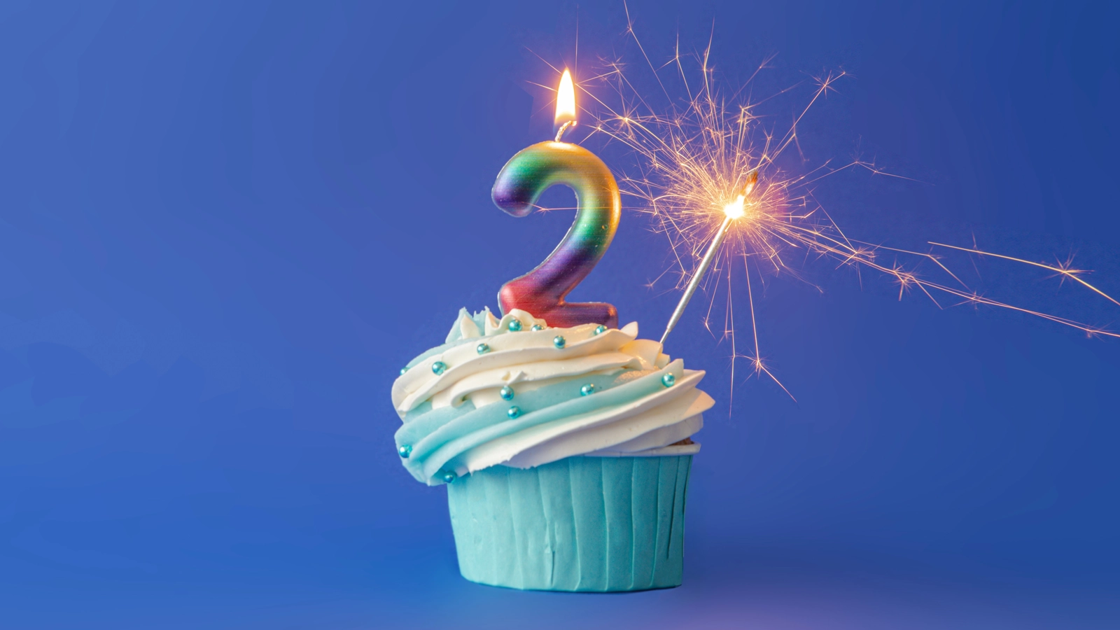 Cupcake with a number two candle and a sparkler, depicting the numeral 2, which is the Fed's target annual inflation rate