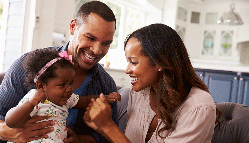 two parents playing with their child