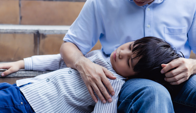 child laying on a parent's lap