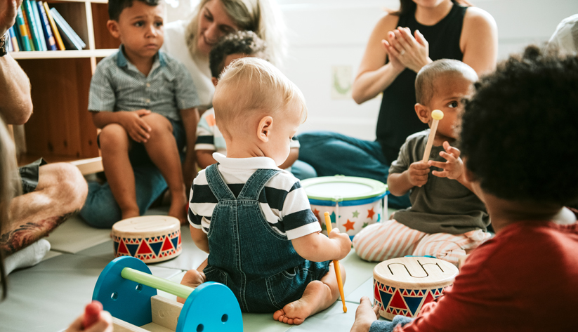 children playing with toys and sitting with adults
