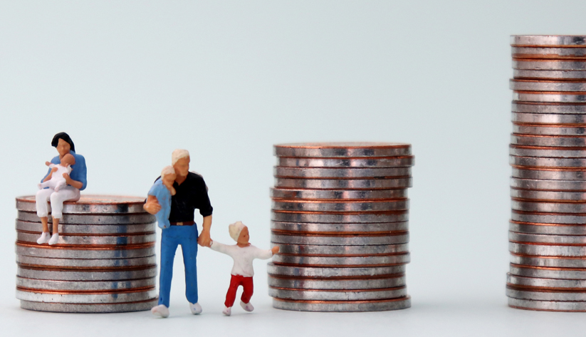 family sitting and standing near two giant stacks of coins