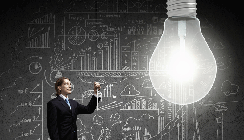 person turning on light bulb in front of chalkboard graph drawings