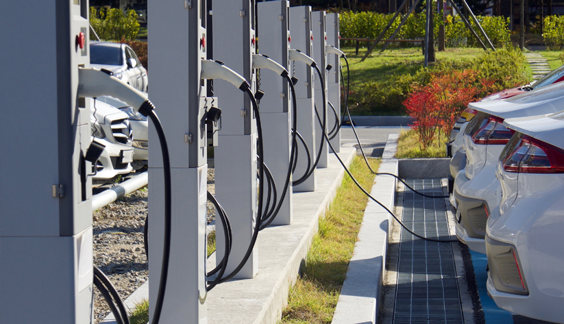 Electric vehicles at charging stations ,some charging some not.