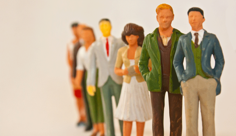 miniature people figurines standing in line