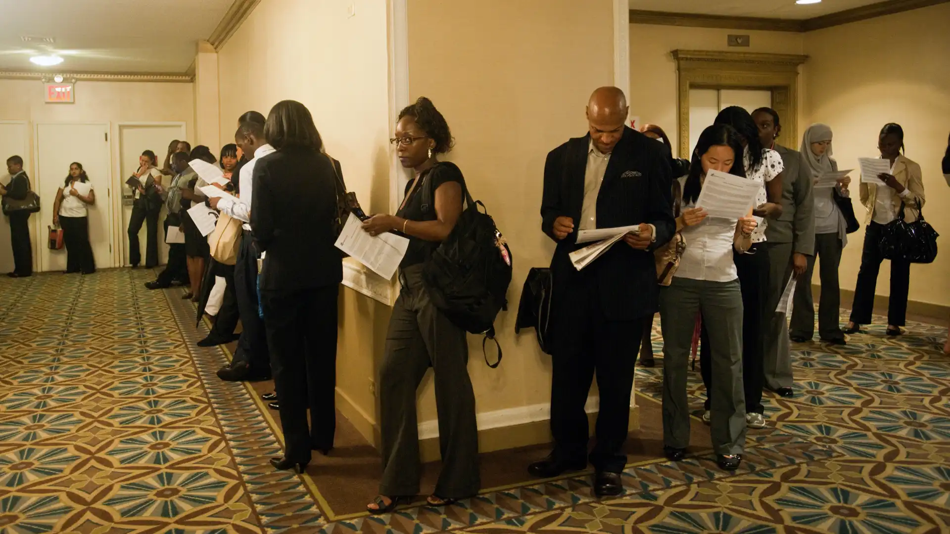 People holding resumes lining up to apply for jobs
