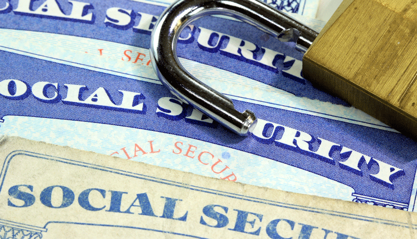 an open padlock laying on top of multiple social security cards