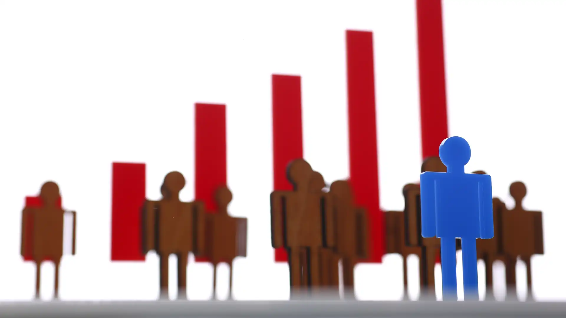 illustration of abstracted people--one blue person in foreground, multiple brown people in middle ground, and red bar chart columns in background