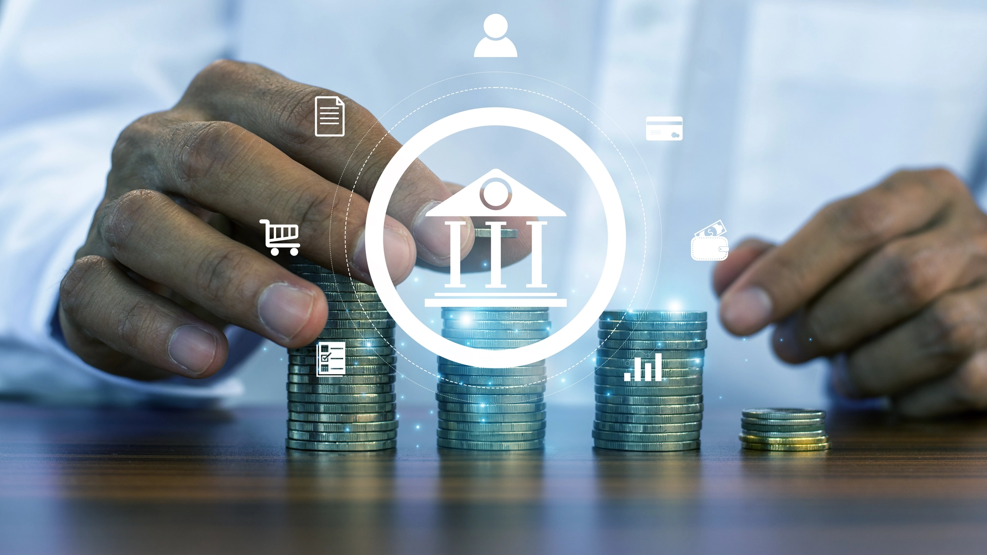 hands adjusting coin piles on a table overlain with an abstract Greek-columned building surrounded with a circle with icons of a document, a shopping cart, a checklist with an item checked, a dollar bill going into a wallet, a payment card, and an abstracted person