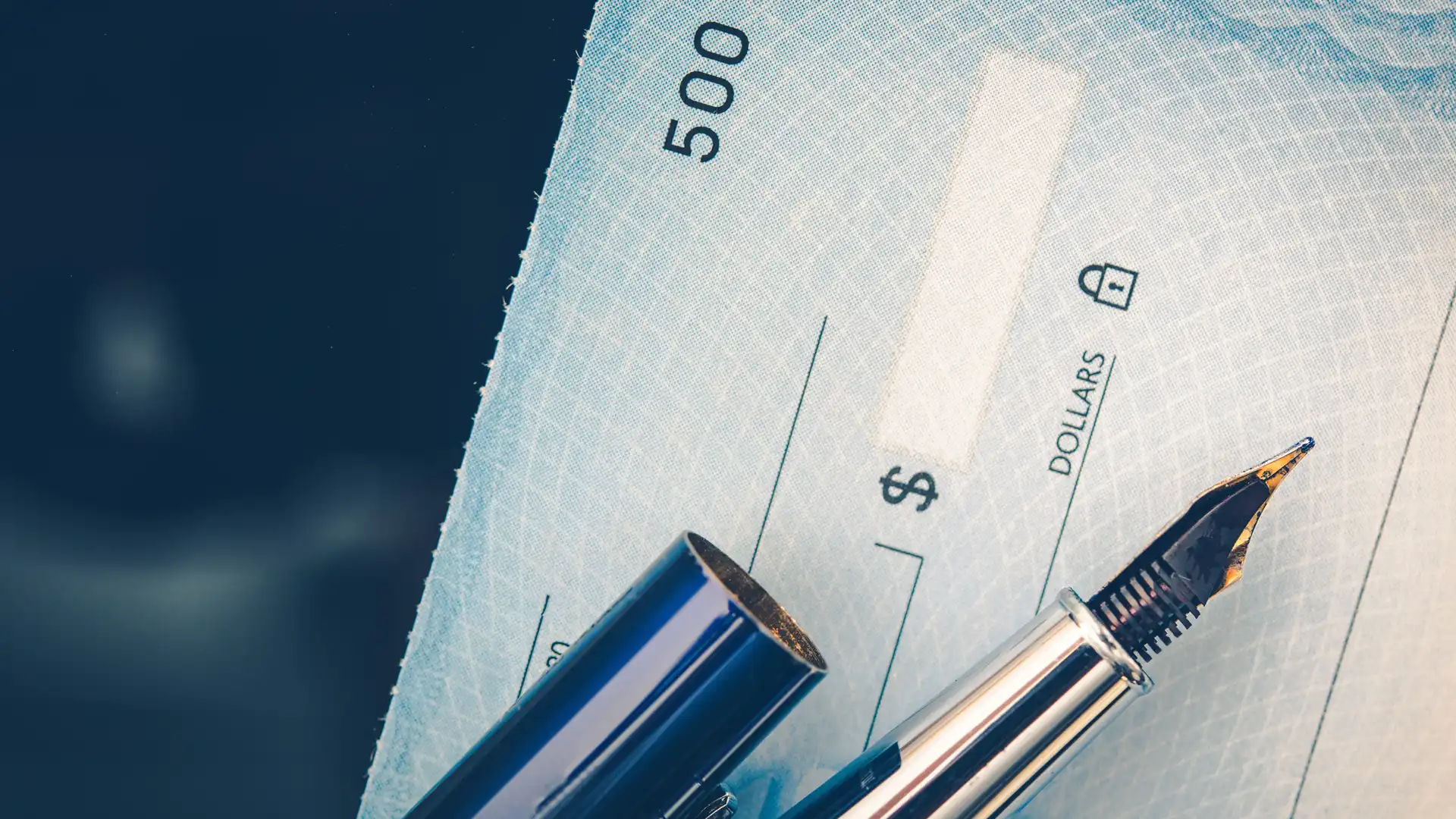 Blue check with pen and pen cap laying on top