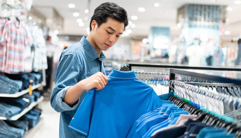 a man looking at clothes in a store