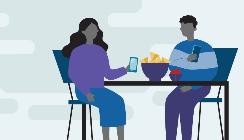 two people sitting at table holding mobile phones with chips and salsa 