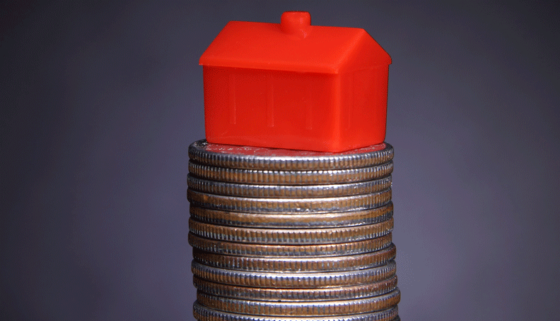 monopoly house on top of coin stack
