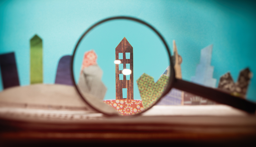 wooden house under a magnifying glass