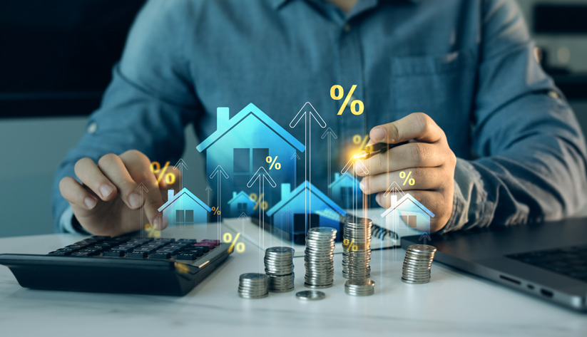 Man using a calculator with stacks of coins with houses and upward pointing arrows superimposed