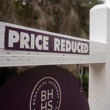 Real estate sign with price reduced label