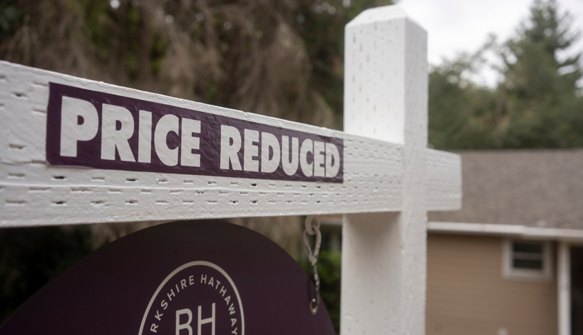 Real estate sign with price reduced label