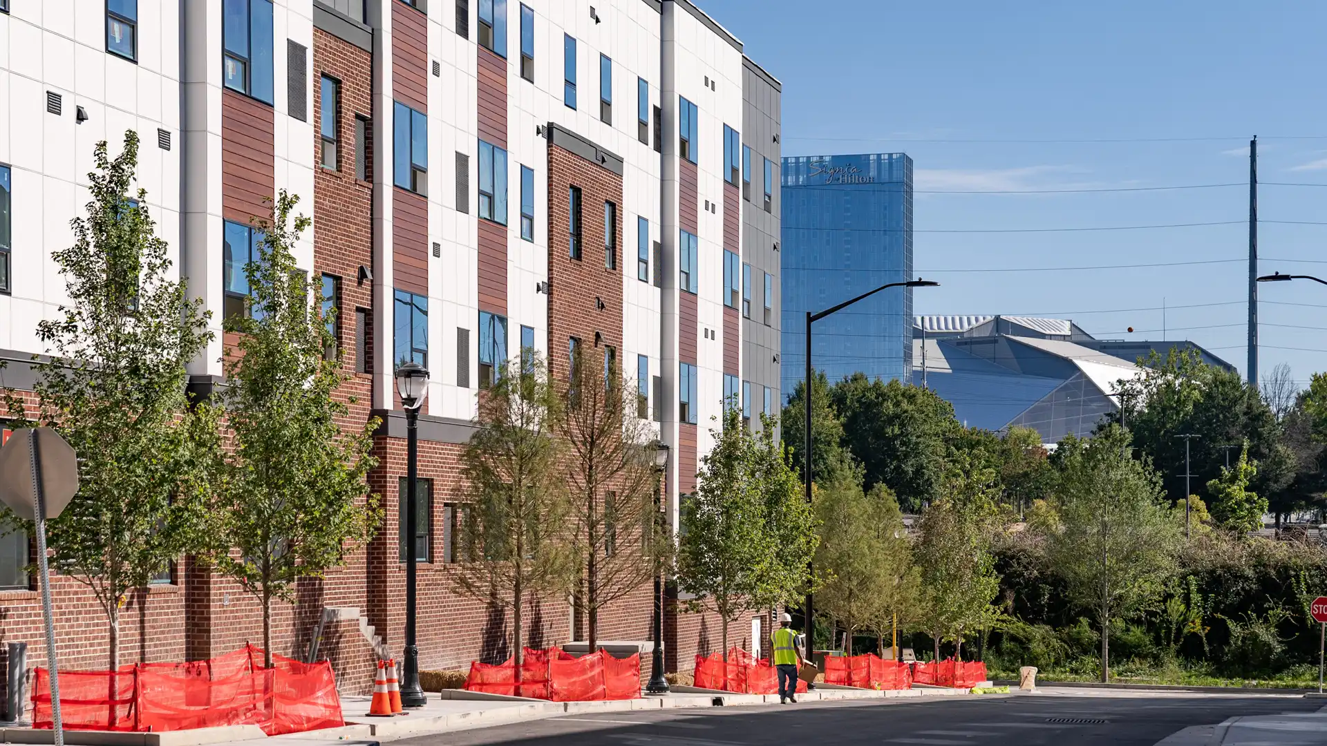 side of a apartment complex with newly planted trees