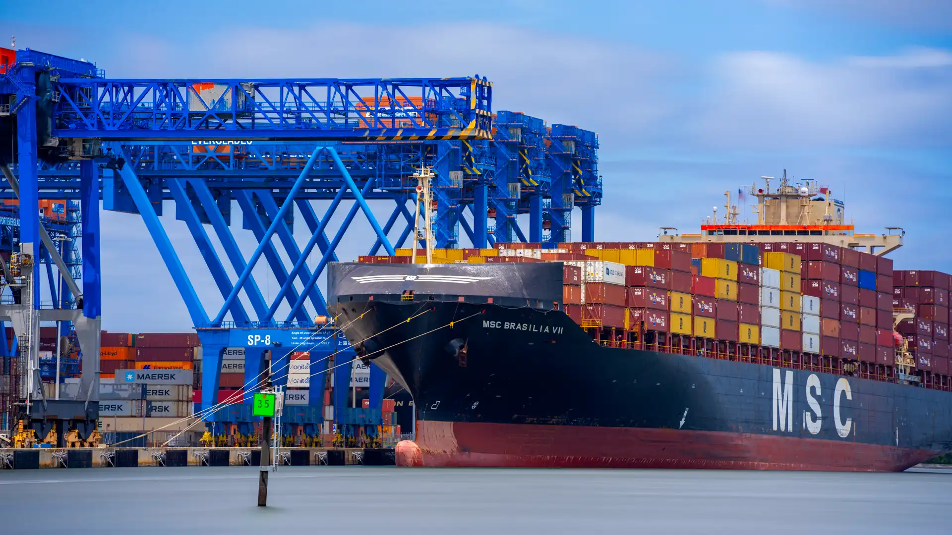 cargo ship at port either being loaded or unloaded of shipping containers
