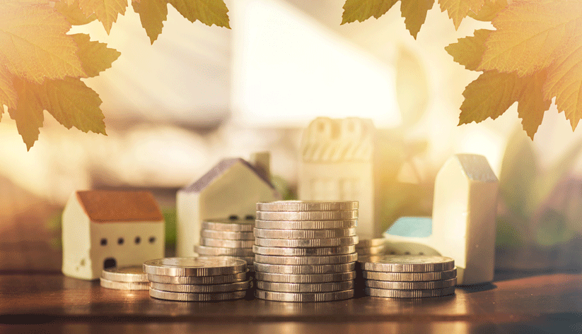 a stack of coins in front of little homes
