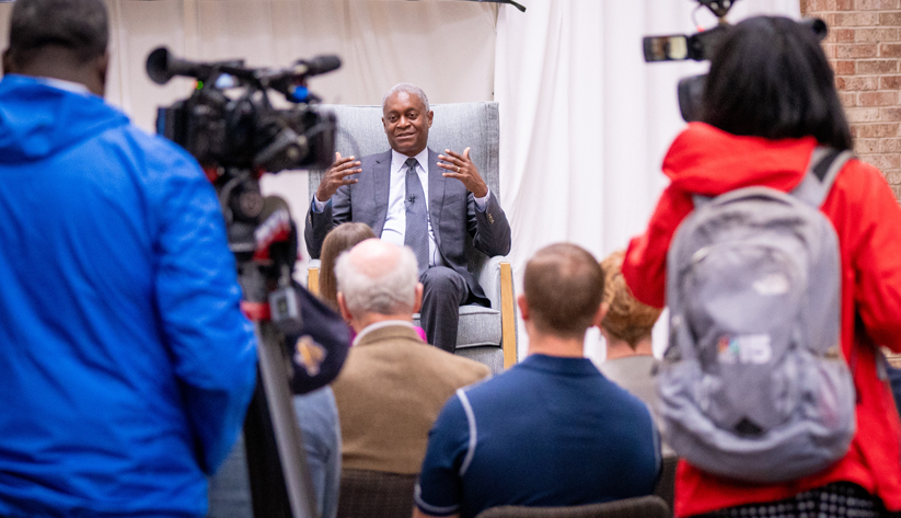Photo of Raphael Bostic speaking before an audience and cameraman.