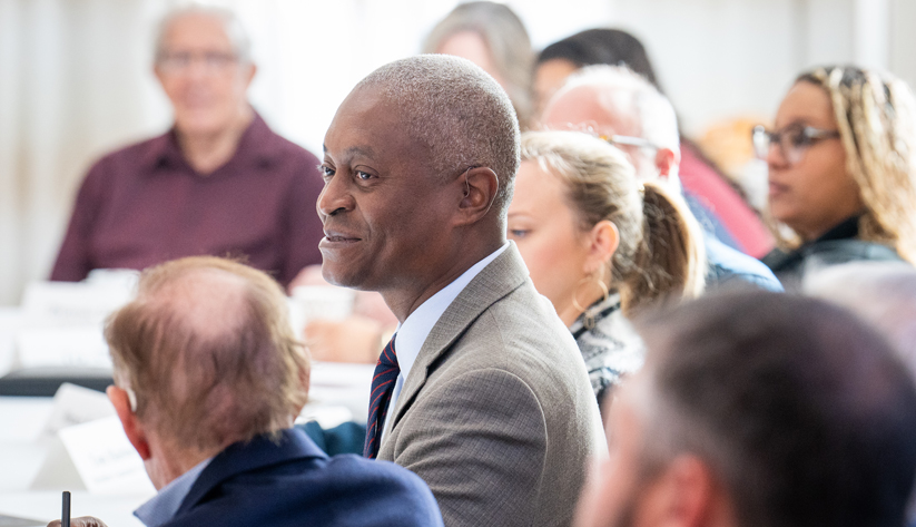 Raphael Bostic sitting at a table with a group of people