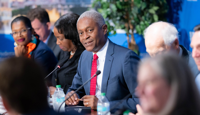Raphael Bostic speaking at a conference table